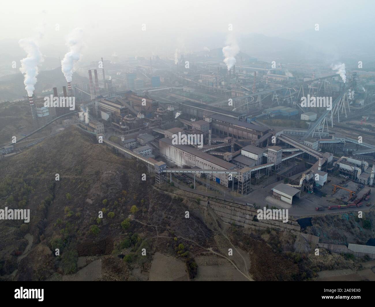 Aerial view of big factory in China. Air pollution by smoke coming out of chimneys. Coal Fossil Fuel Power Plant Smokestacks Emit Carbon Dioxide Pollution. Chengde, China. December, 12th, 2019 Stock Photo