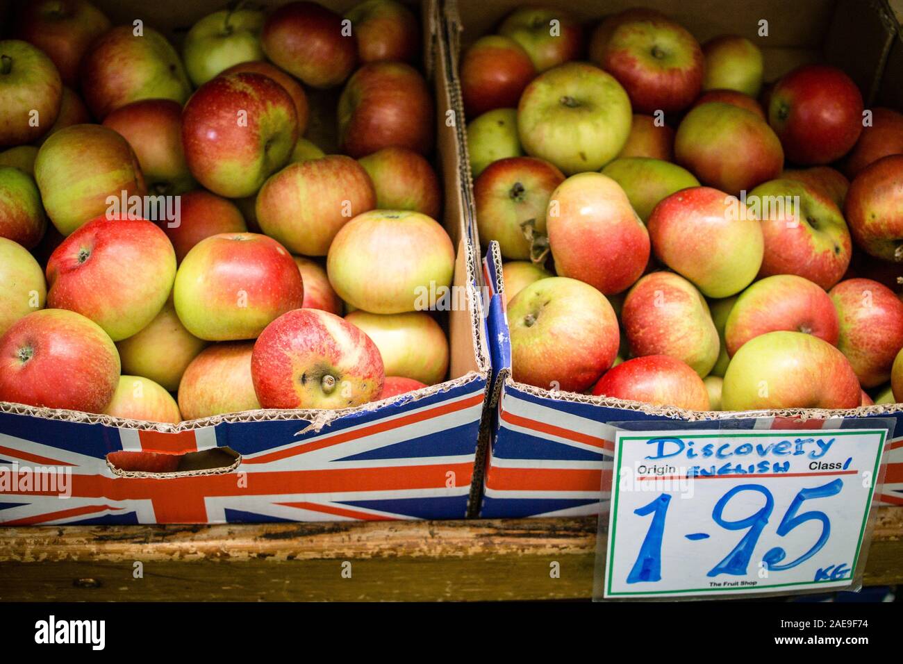 Boxes of Discovery Apples on sale at The Fruit Shop - independent family run green grocer in rural Berkshire - handwritten price label. £1.95 /kg Stock Photo