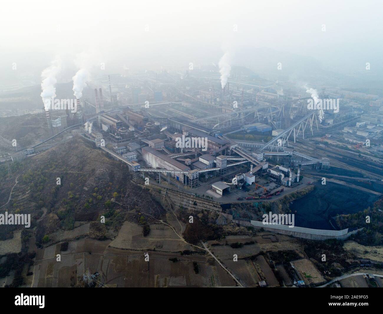 Aerial view of big factory in China. Air pollution by smoke coming out of chimneys. Coal Fossil Fuel Power Plant Smokestacks Emit Carbon Dioxide Pollution. Chengde, China. December, 12th, 2019 Stock Photo