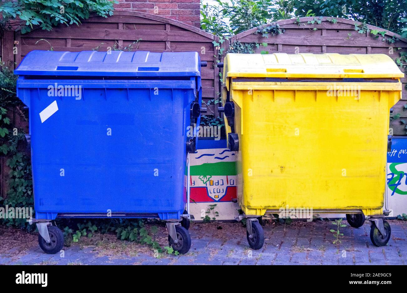 Blue plastic and yellow plastic wheelie bins in Cuxhaven Lower Saxony Germany. Stock Photo