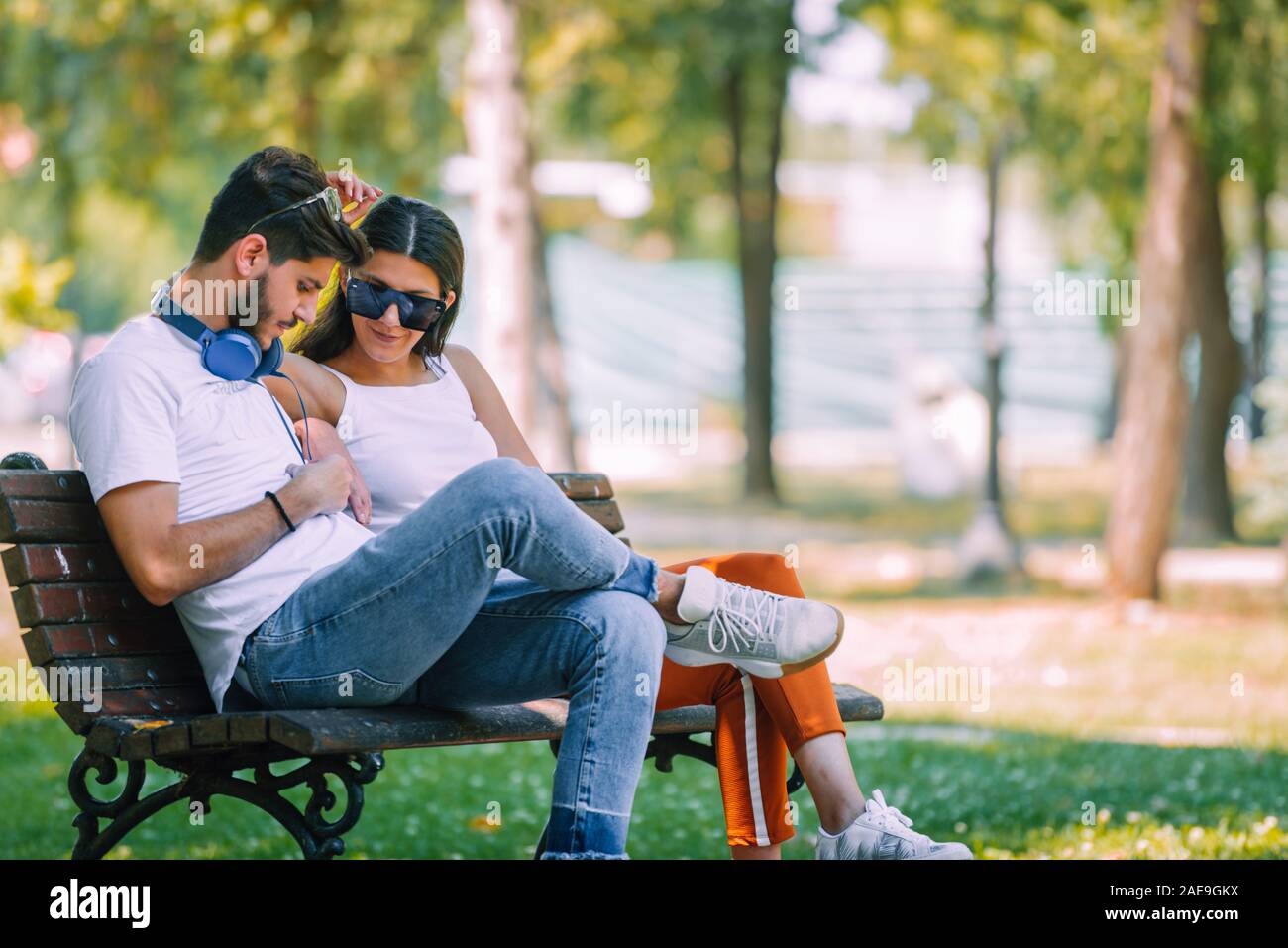 Back view of beautiful love couple sitting outdoors on a bench looking each  other Stock Photo - Alamy