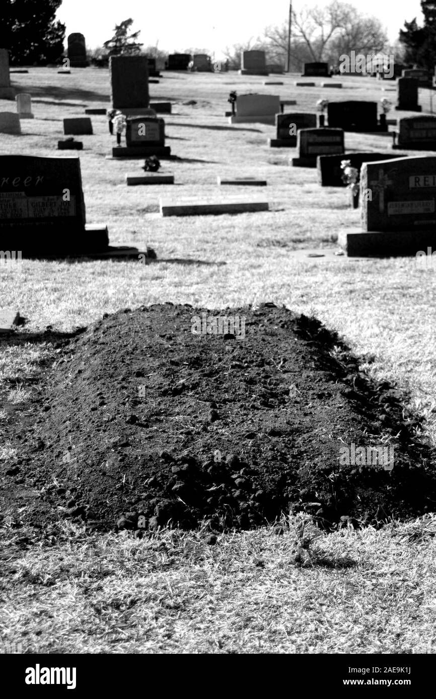 A fresh mound of dirt means another life lost, but the horrors of death are really for the living to suffer as this person now lies in peace Stock Photo