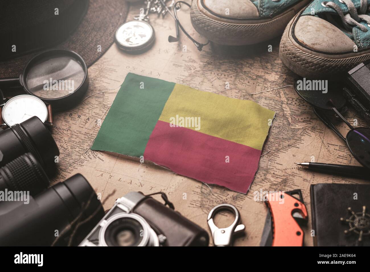 Benin Flag Between Traveler's Accessories on Old Vintage Map. Tourist Destination Concept. Stock Photo