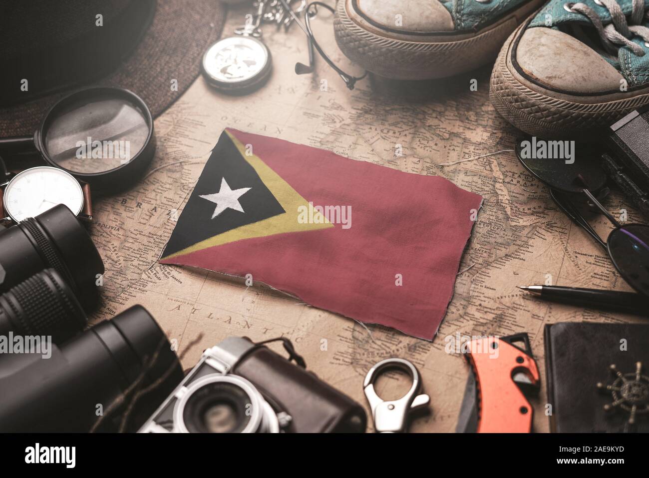 East Timor Flag Between Traveler's Accessories on Old Vintage Map. Tourist Destination Concept. Stock Photo