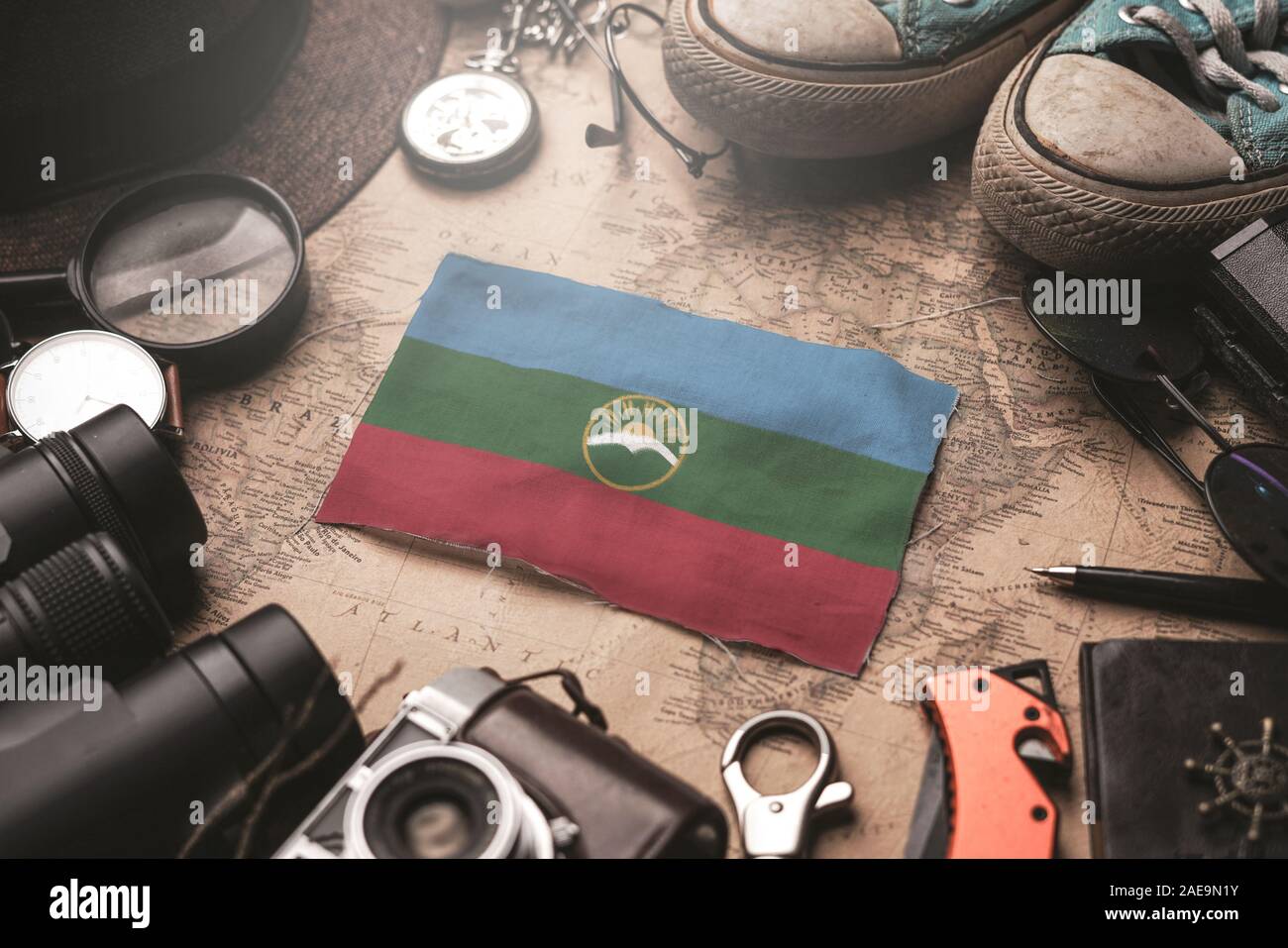 Karachay-Cherkessia Flag Between Traveler's Accessories on Old Vintage Map. Tourist Destination Concept. Stock Photo