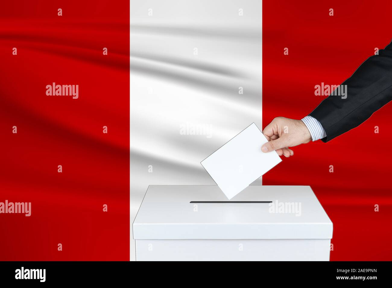 Election in Peru. The hand of man putting his vote in the ballot box. Waved Peru flag on background. Stock Photo