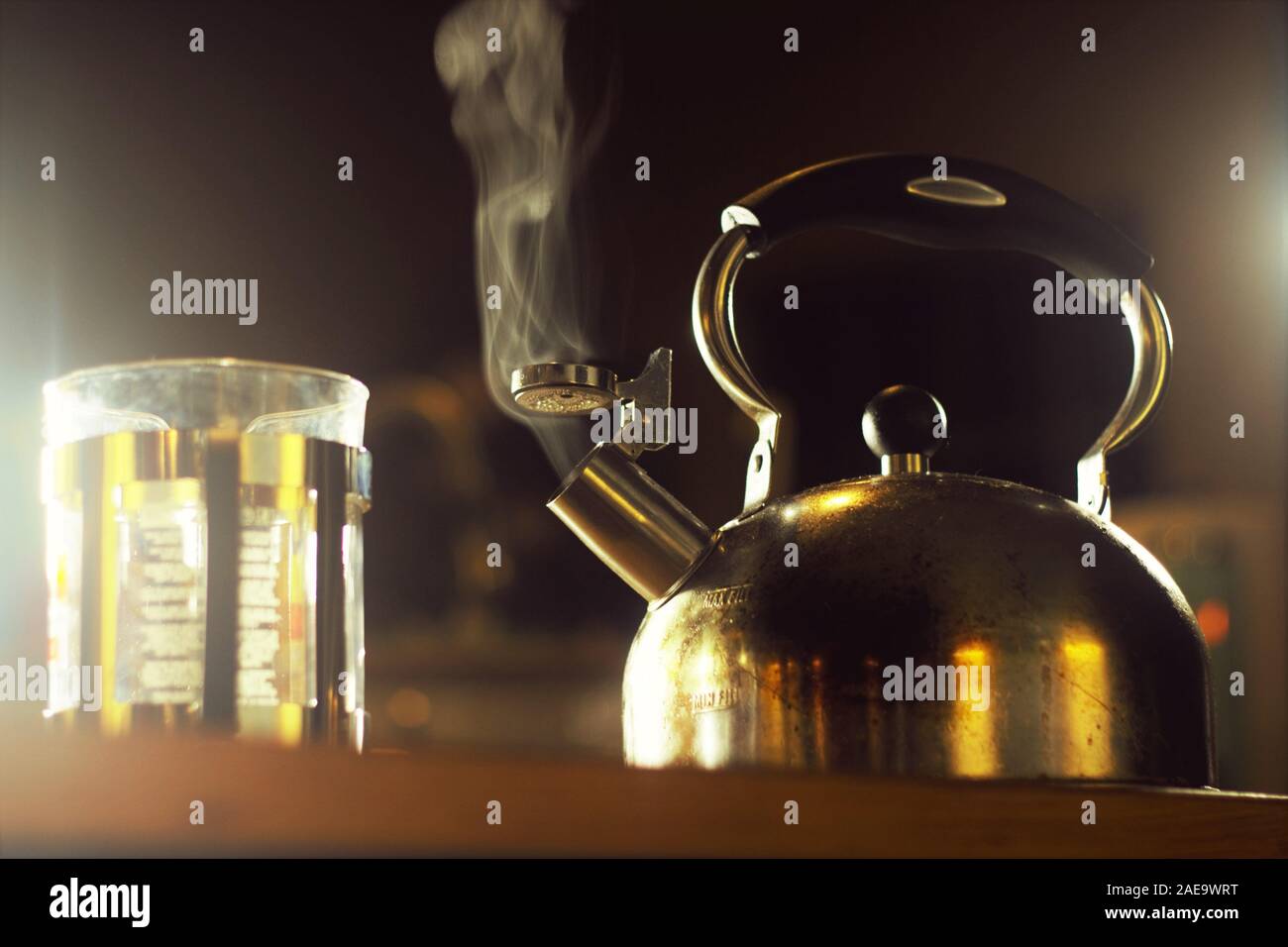 Low Angle Shot of Steaming Kettle with French Press Coffee Maker Stock Photo