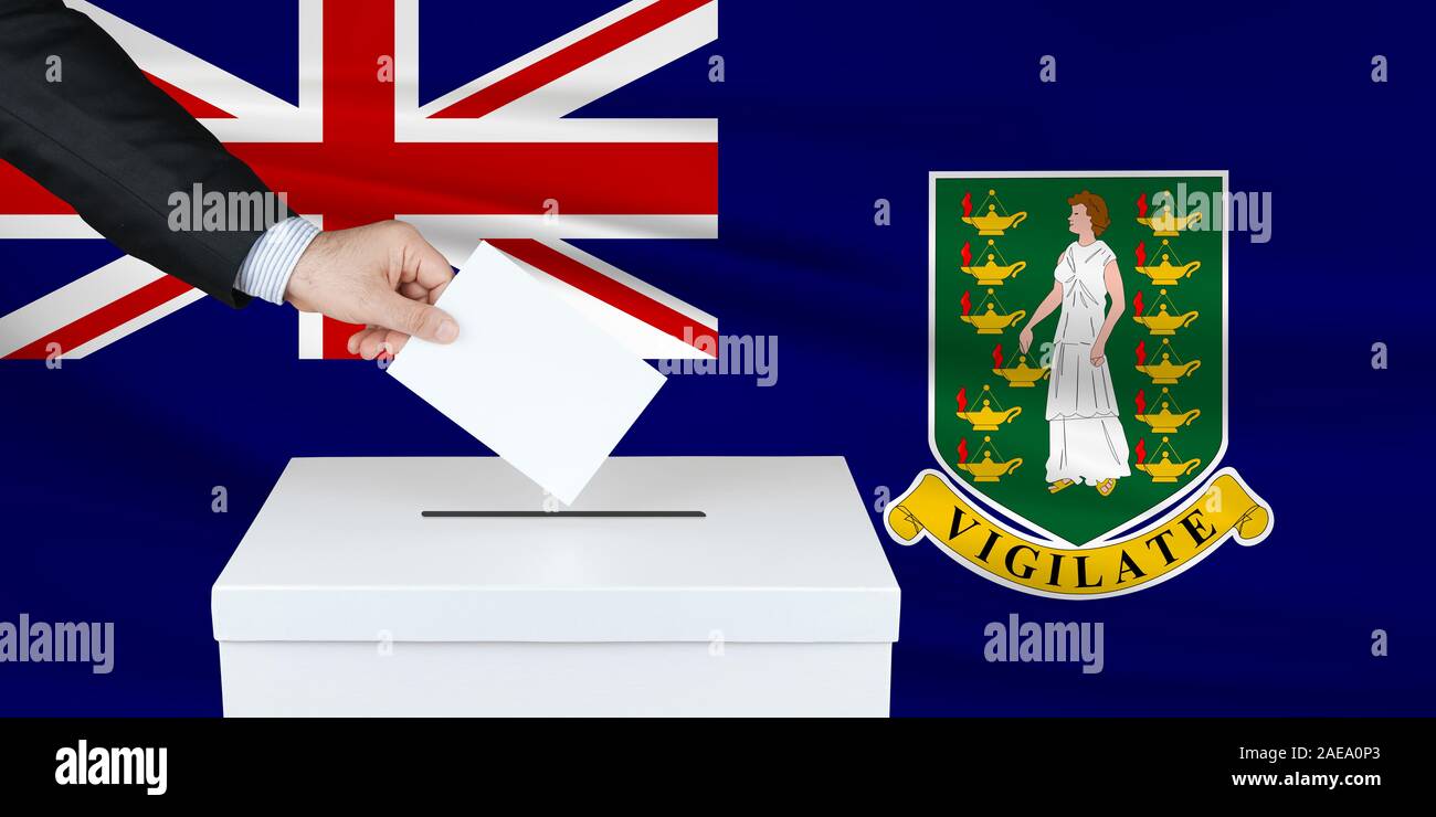 Election in Virgin Islands UK. The hand of man putting his vote in the ballot box. Waved Virgin Islands UK flag on background. Stock Photo