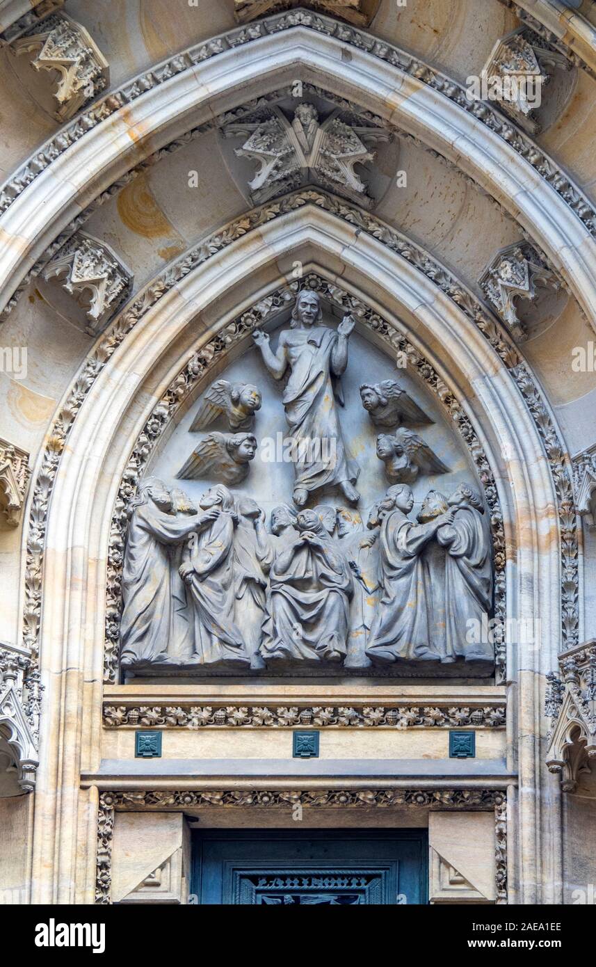 Detail of bronze sculpture and sandstone carvings above side  portal of Gothic St Vitus Cathedral Prague Castle Complex Prague Czech Republic. Stock Photo