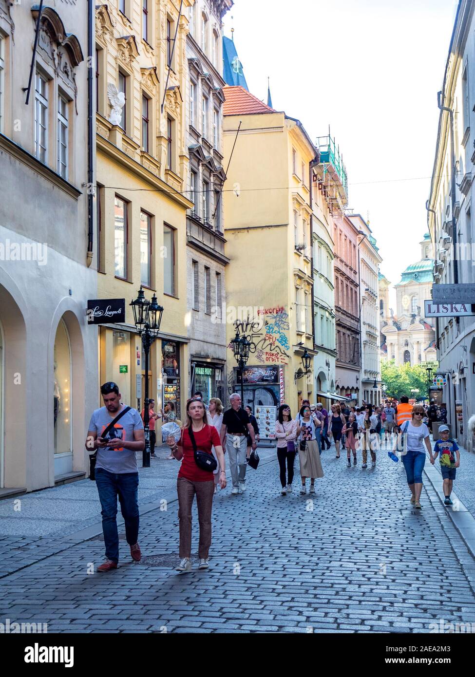 Crowds of tourists walking along cobblestone Železná street lined with touristic shops and cafes Old Town Prague Czech Republic. Stock Photo
