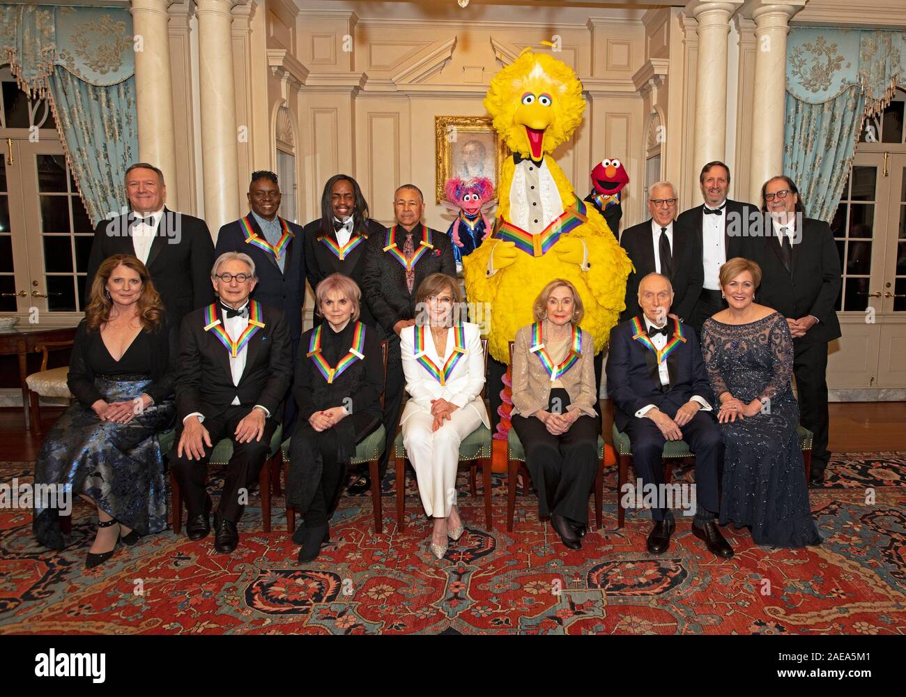 Washington DC, USA. 07th Dec, 2019. The recipients of the 42nd Annual Kennedy Center Honors pose for a group photo following a dinner at the United States Department of State in Washington, DC on Saturday, December 7, 2019. From left to right back row: United States Secretary of State Mike Pompeo; from the band Earth, Wind & Fire, singer Philip Bailey, bassist Verdine White, and percussionist Ralph Johnson; from Sesame Street, Abby, Big Bird, Elmo; David M. Rubenstein, Chairman, John F. Kennedy Center for the Performing Arts; producers Ricky Kirshner and Glenn Weiss. Front row, left to right:  Stock Photo