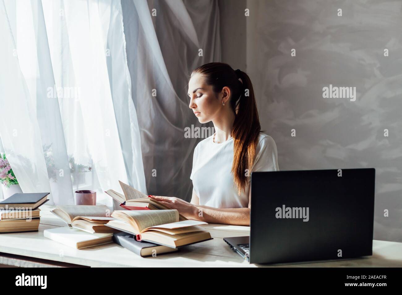 girl works at the computer reads books Stock Photo - Alamy