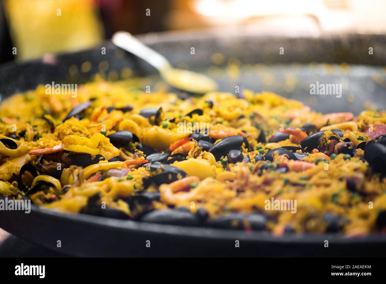 Large pot of freshly cooked paella with saffron rice, seafood and mussels in a low angle view with selective focus and copy space in a catering concep Stock Photo