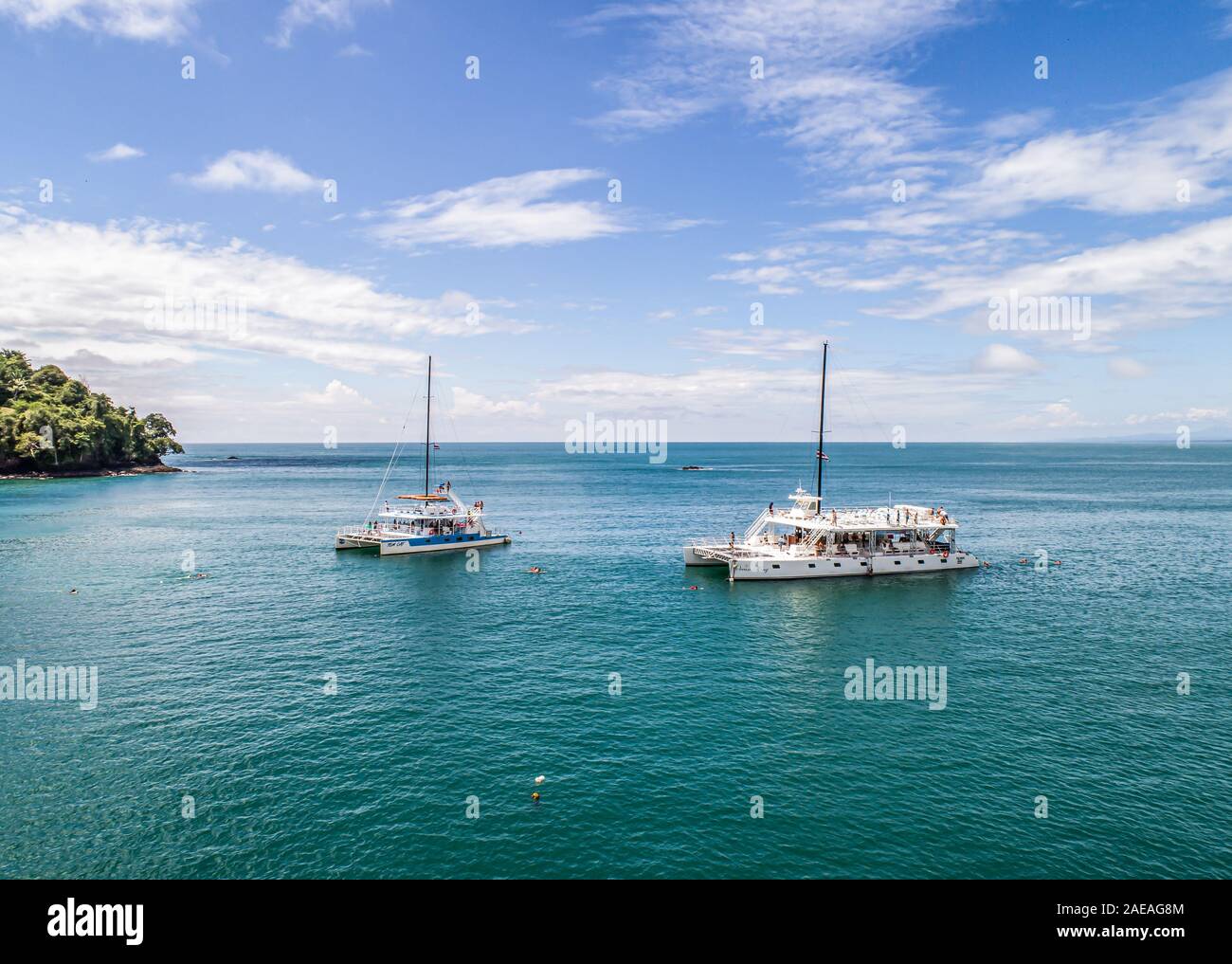 Manuel Antonio Costa Rica 02.11.2019 drone shot white catamaran yacht excurison boat anchoring in a beautiful blue bay in front of an empty beach in C Stock Photo