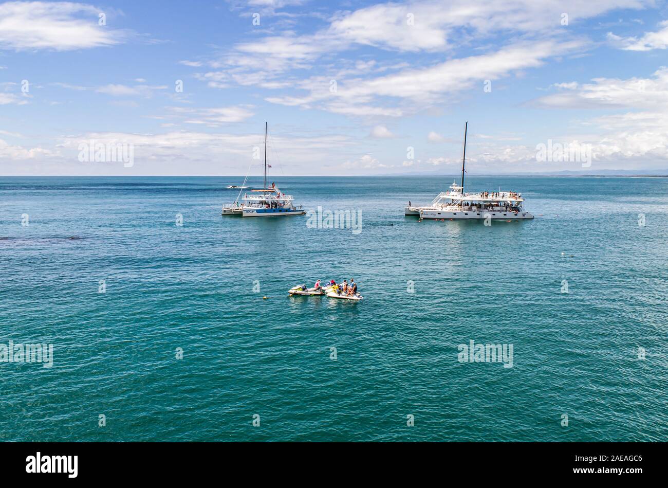 Manuel Antonio Costa Rica 02.11.2019 drone shot white catamaran yacht excurison boat anchoring in a beautiful blue bay in front of an empty beach in C Stock Photo