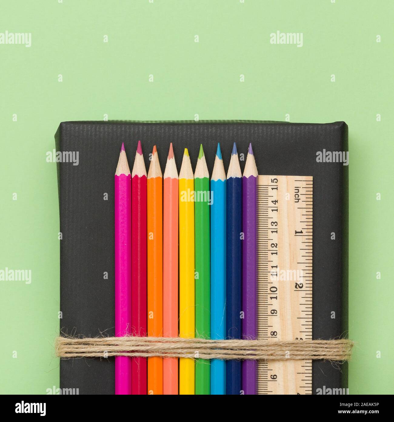 https://c8.alamy.com/comp/2AEAK5P/colorful-school-and-office-supplies-pencils-and-ruler-on-black-book-and-light-green-background-top-view-with-copy-space-2AEAK5P.jpg