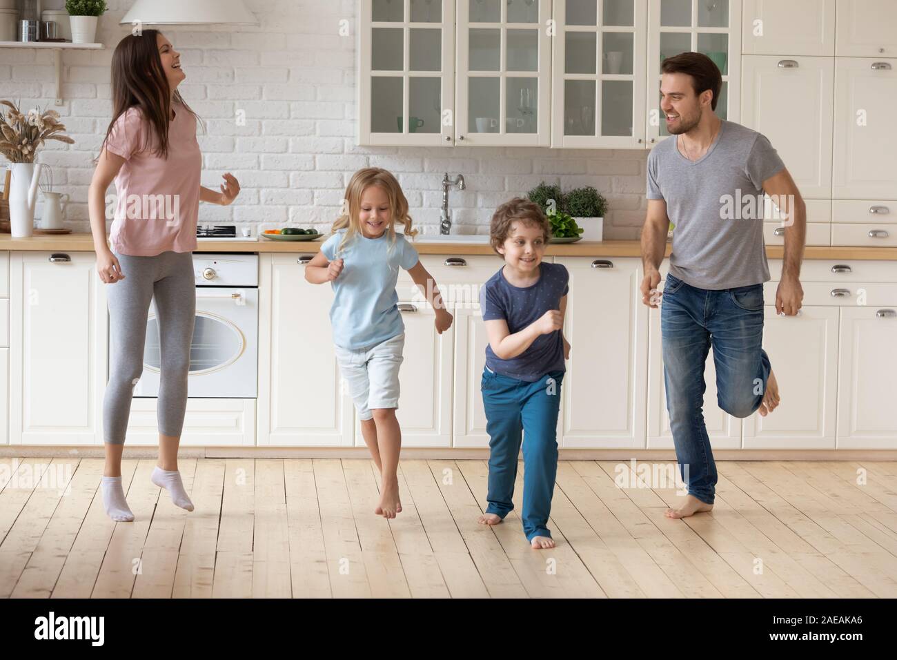 Family with little kids dancing in the kitchen Stock Photo