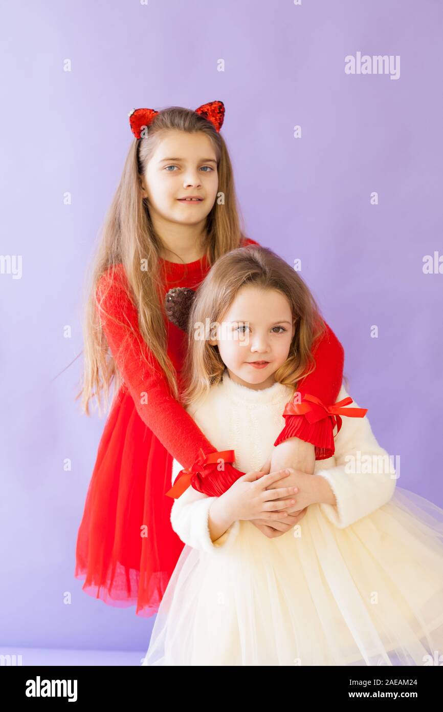 Two beautiful little girls in red white dresses Stock Photo - Alamy