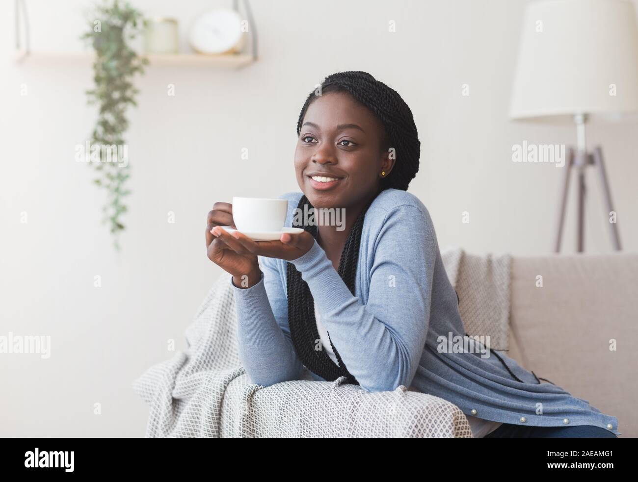 Happy black girl relaxing with cup of tea at home Stock Photo - Alamy