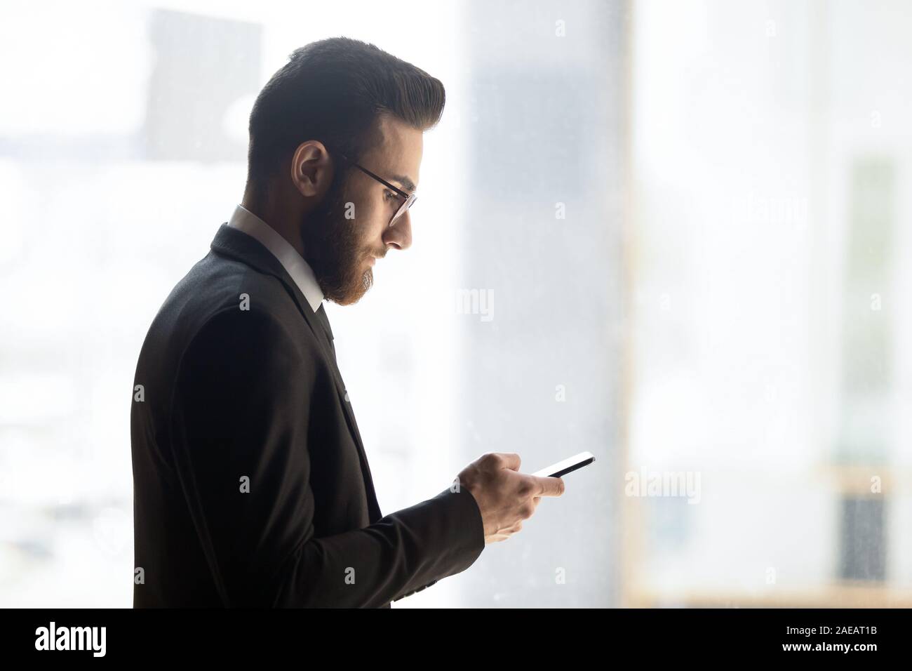 Young Arabic businessman using smartphone checking mail Stock Photo