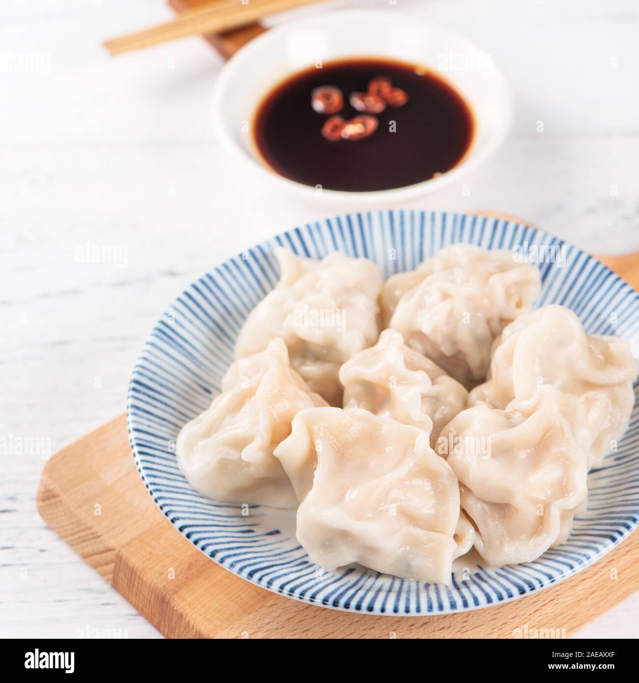 Fresh, delicious boiled pork gyoza dumplings, jiaozi on white background  with soy sauce and chopsticks, close up, lifestyle. Homemade design concept  Stock Photo - Alamy
