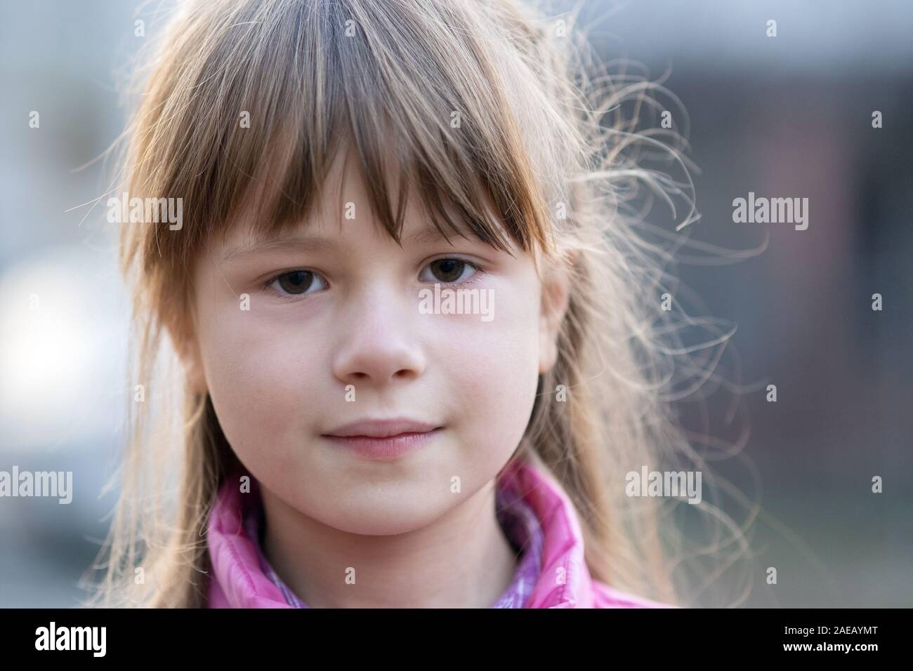 Portrait of happy child girl in warm clothes in autumn outdoors. Stock Photo