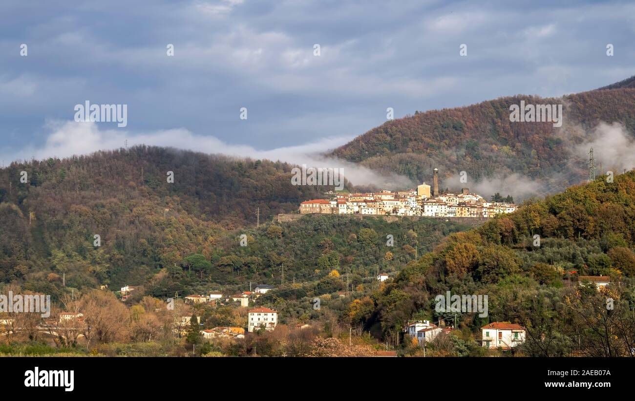 Caprigliola near Aulla, Massa Carrara, Italy, medieval hilltop village in autumn mist. Rolling hills of Lunigiana. Stock Photo