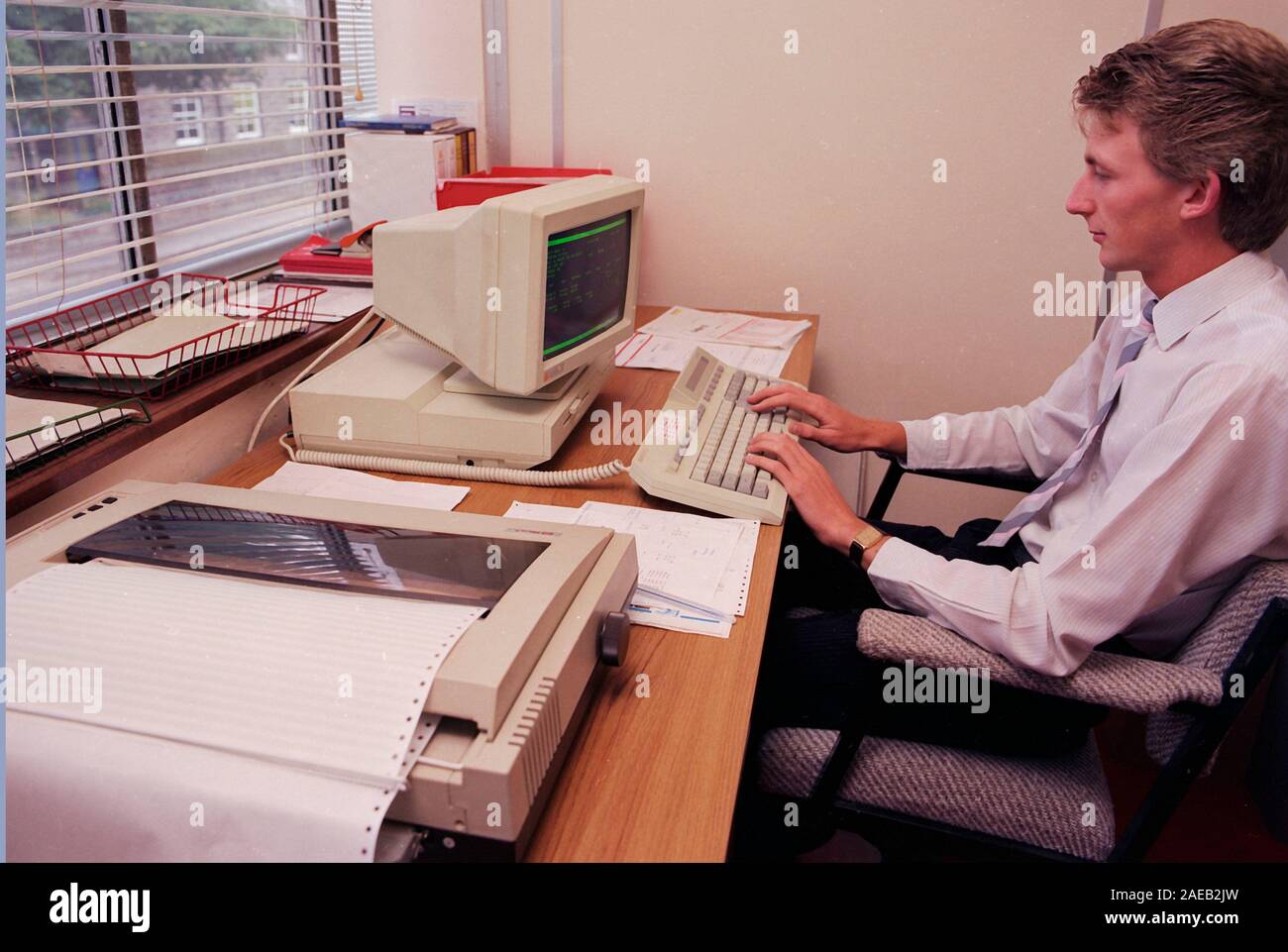 1980's engineering works, Northern England, UK, man at old computer Stock Photo