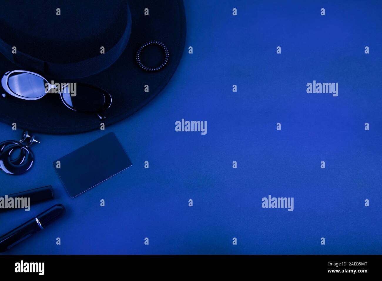 Black monochromatic flatlay on black background. Accessories and beauty
