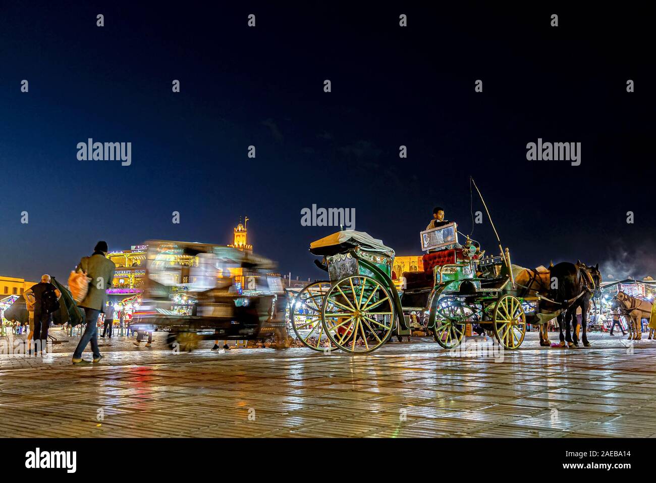 Night lights, vendors and caleche at UNESCO World Heritage Jamaa el Fna or Jemaa el-Fnaa  or Djema el-Fna market square in Medina quarter of Marrakesh Stock Photo