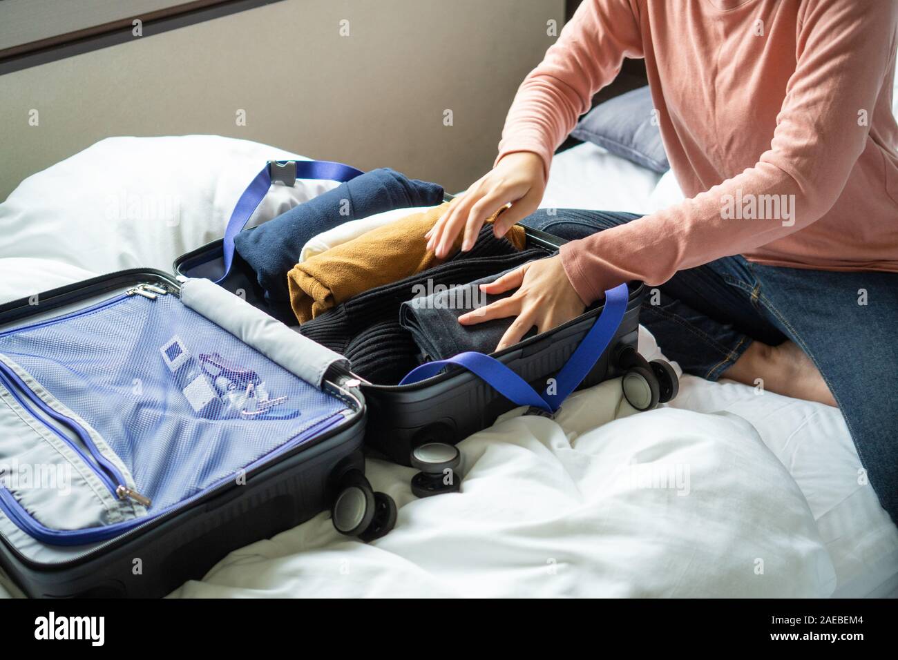 https://c8.alamy.com/comp/2AEBEM4/happy-young-woman-hands-packing-clothes-into-travel-luggage-on-bed-at-home-or-hotel-room-for-a-new-journey-tourism-and-vacation-concept-2AEBEM4.jpg