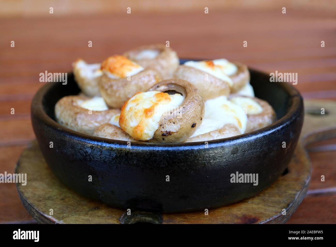 Closeup Soko Ketze or Georgian Stuffed Mushrooms with Sulguni Cheese in a Clay Dish Stock Photo