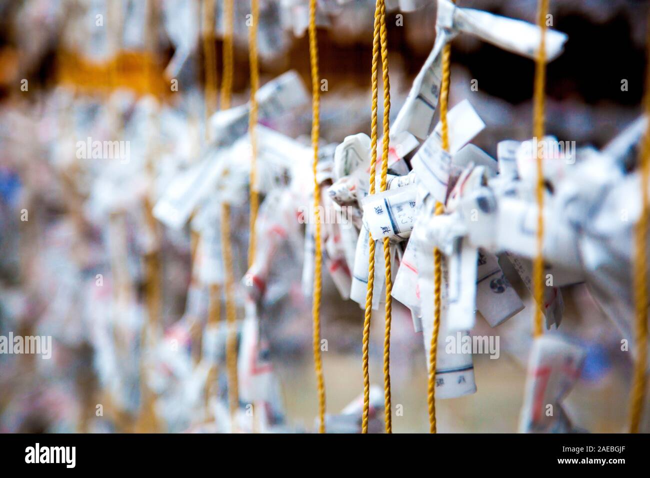 Paper prayers and wishes tied to a rope at the Yasaka Shrine in Kyoto, Kansai, Japan Stock Photo