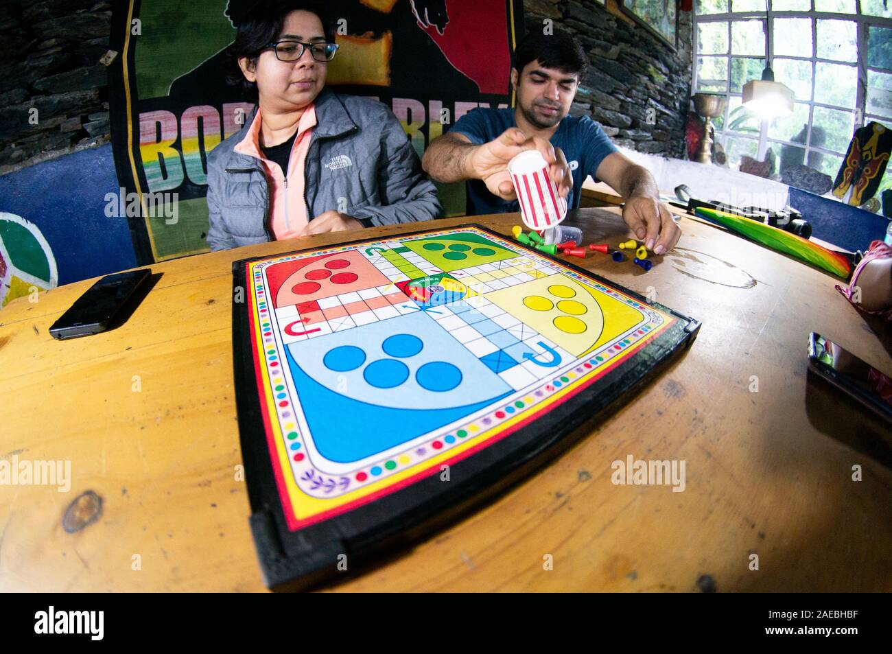 Fisheye shot of young men and women playing board game ludo at a cafe Stock Photo
