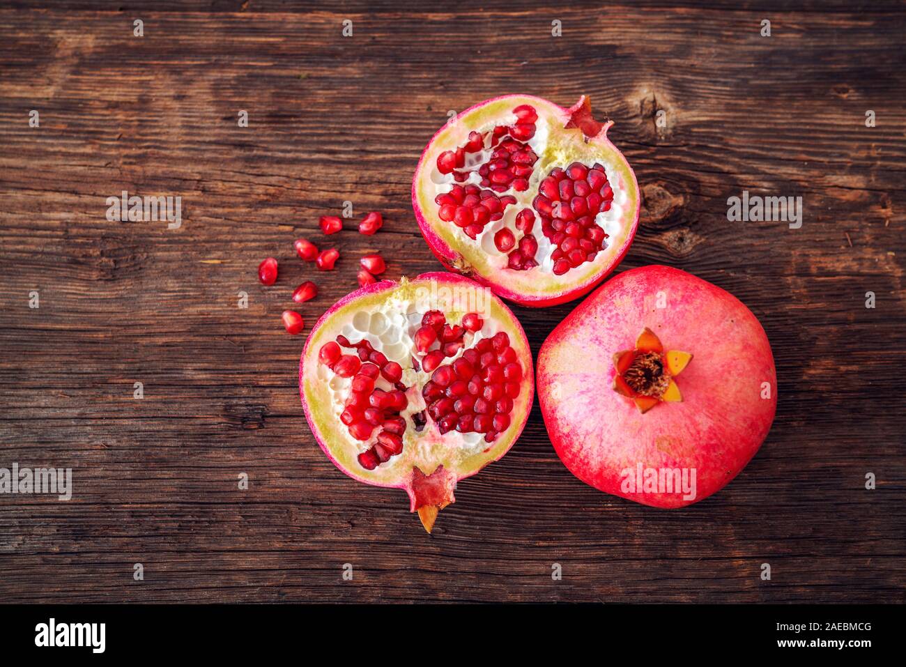 Ripe and fresh pomegranate peeled and ready for eat on wooden beackground. Stock Photo