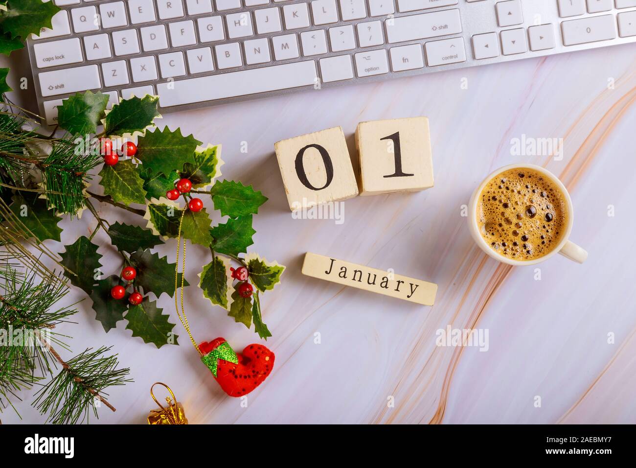 1 January New Year Day office desk table with computer keyboard and coffee cup with decorated christmas tree top view copy space Stock Photo