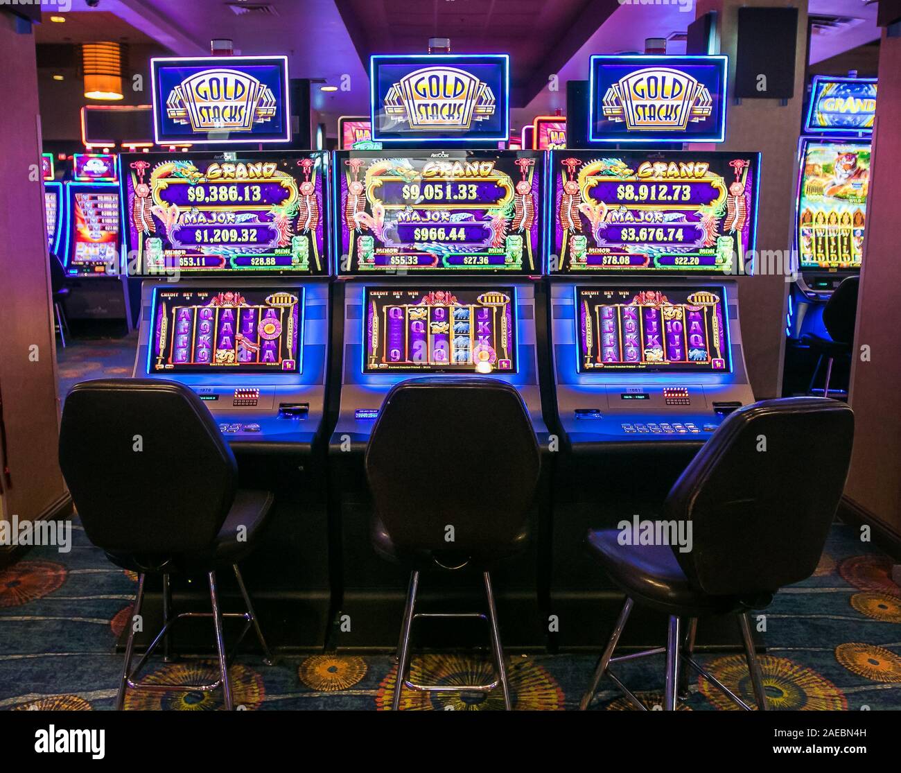 Aruba, 11/28/2019: Empty chairs in front of  video slot machines await their patrons inside Stelaris Casino that is a part of Marriott Hotel. Stock Photo