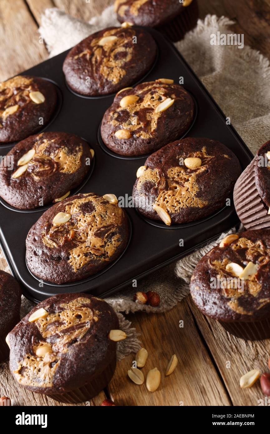 Chocolate peanut muffins in a baking dish on the table. vertical Stock Photo
