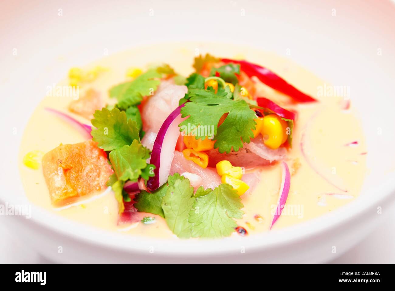Sea bass ceviche with pumpkin, cilantro, corn and onion in deep plate