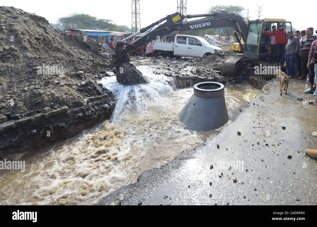 People look at the city road caved due to bursting of a drinking water