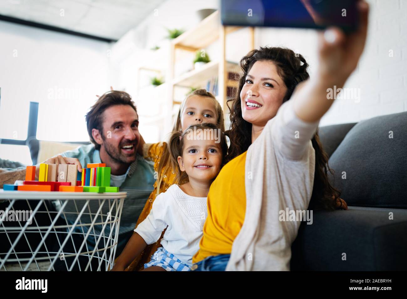 Happy young family take a self portrait with smart phone. Stock Photo