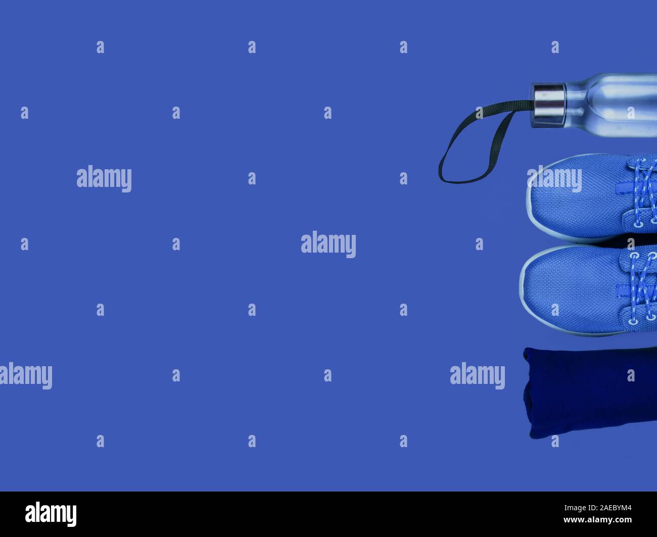 Creative flat lay of sport and fitness equipments on blue background. Stock Photo