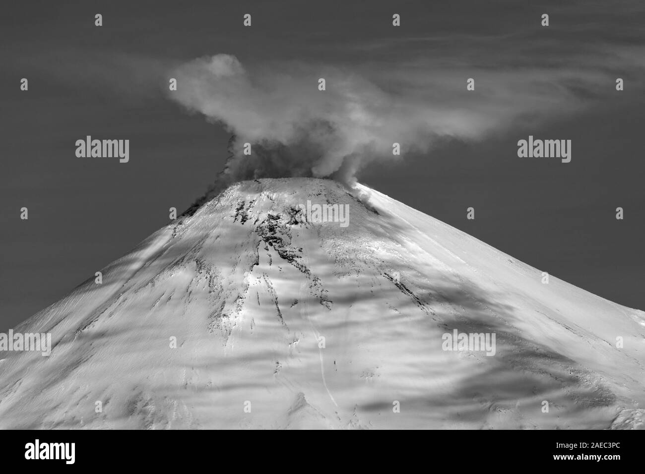 Volcano Avachinskaya Sopka - active mount of Kamchatka Peninsula. Winter volcanic activity of mount: steam, gas, ashes eruption from crater Stock Photo