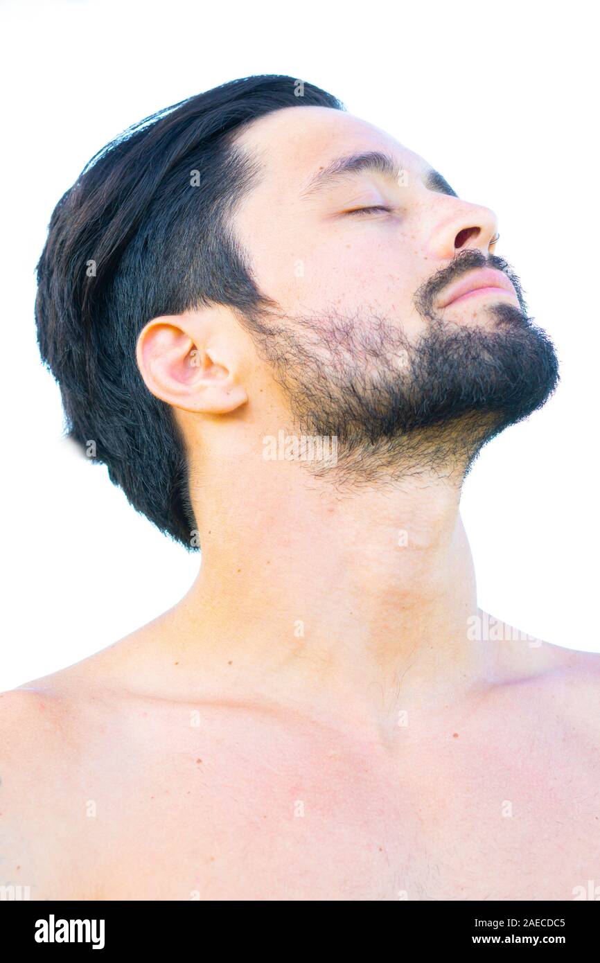 Close up profile portrait of healthy man with black hair and beard, tilting his head back Stock Photo