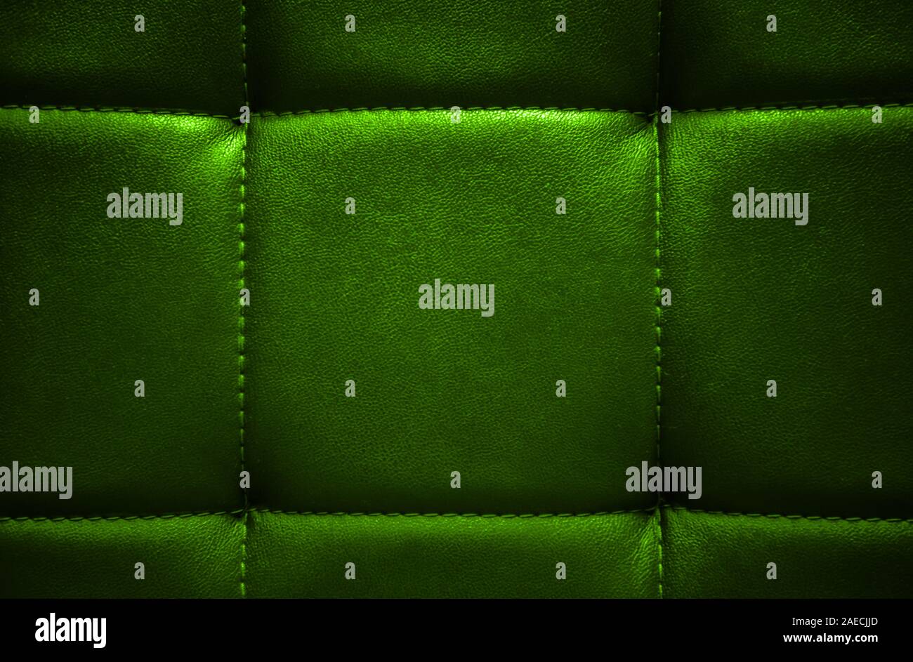 Shiny electric green artificial textured leather stitched with thread. Close-up of sofa surface. View from directly above. Highly detailed background Stock Photo