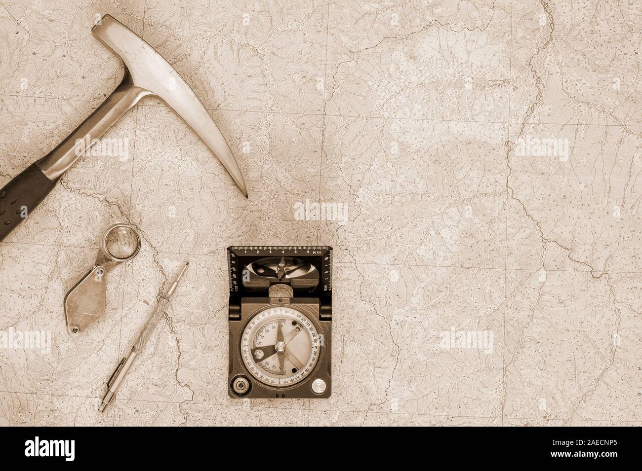 The tools of the geologist laid out on a topographic map. Background