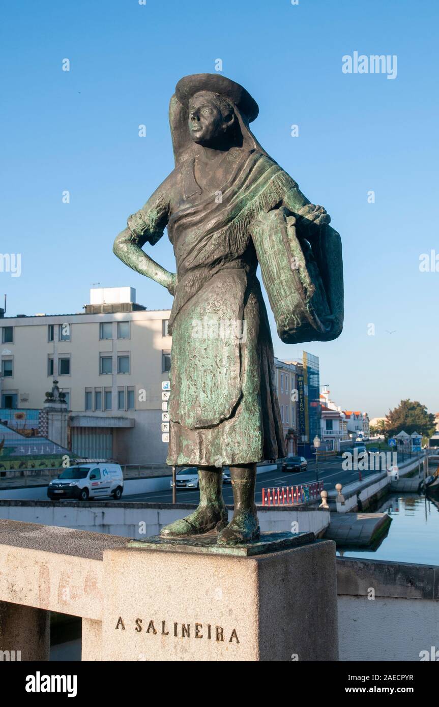 Bronze statue of a female salt worker (Salineira) overlooking the canal, Aveiro, Portugal Stock Photo