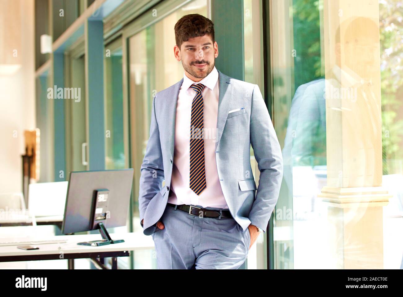 Portrait of confident young businessman wearing suit and tie while ...