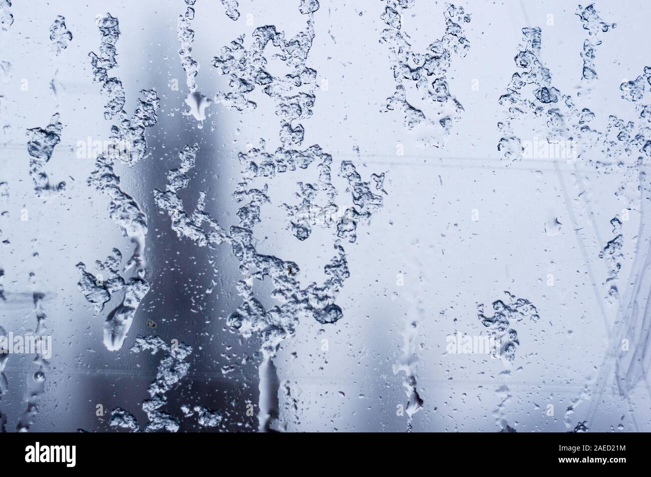 glass in the window covered with wet melting snow, close-up, macro Stock Photo