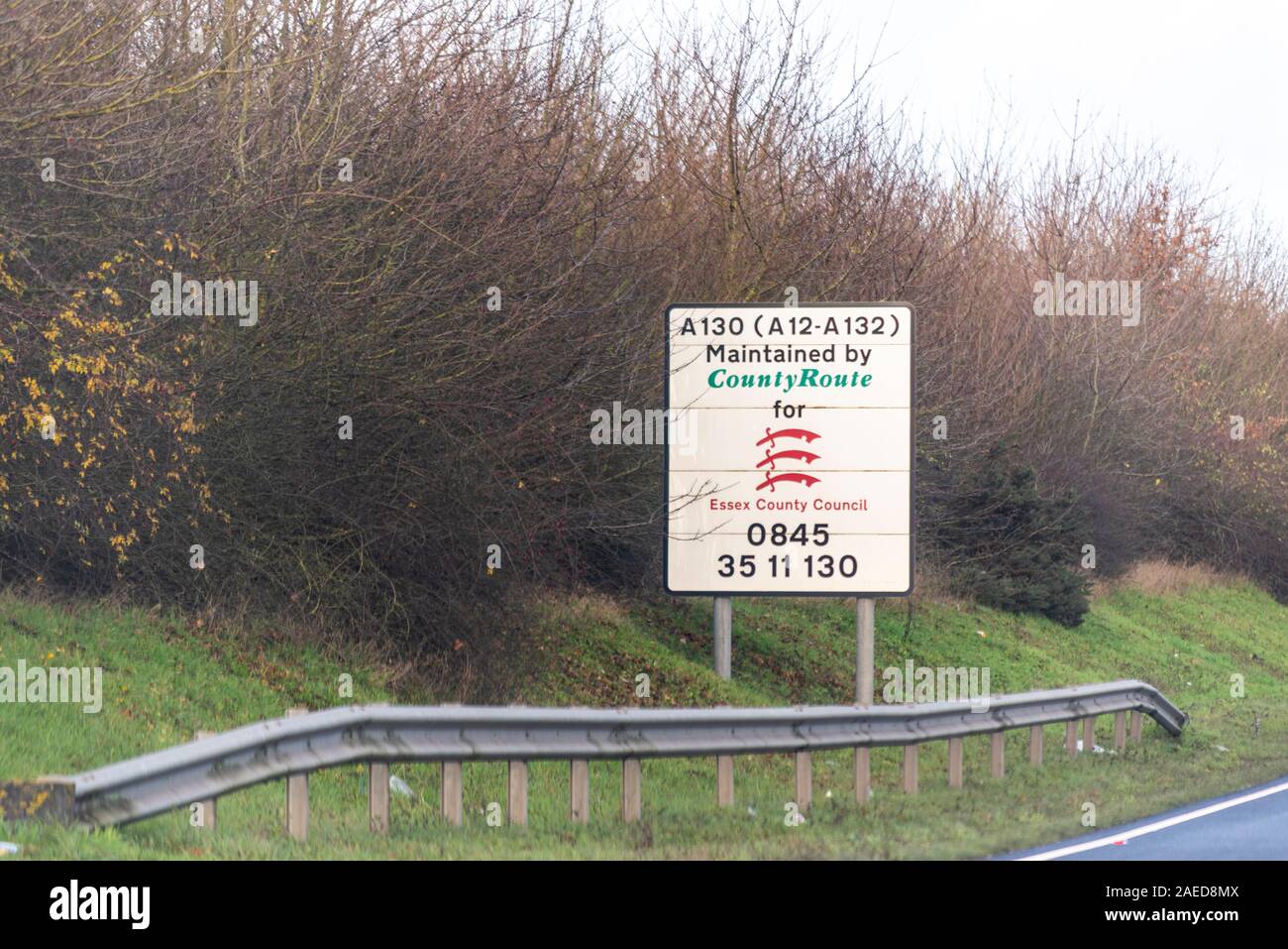 Sign on a stretch of A130 carriageway from A12 to A132 stating maintained by County Route for Essex County Council with phone number. Road network Stock Photo